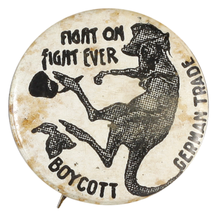 This badge was produced during the First World War as a patriotic fundraising badge, urging Australians to support the war by boycotting German goods. It features a boxing kangaroo wearing a slouch hat.